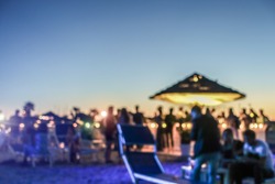 Blurred people having sunset beach party in summer vacation - Defocused image - Concept of nightlife with cocktails and music entertainment - Warm filter with blurry bokeh