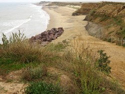 The North coast of Norfolk near Snettisham showing path leading down to a beach with various places on the cliff subject to coastal erosion.