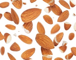 Almonds flying randomly in the air on a white background