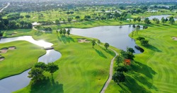 Aerial view of green grass and trees on a golf field, fairway and putting green top view, Bangkok Thailand. bird view over Golf course in the tropical Bangkok.