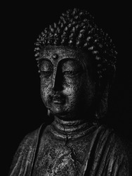 Buddha face black in front of black background mystical religious lowkey