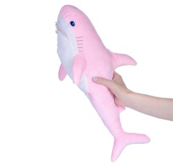 Soft toy pink shark in hand on white background isolation