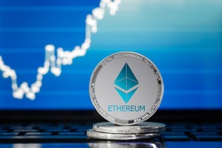 ETHEREUM (ETH) cryptocurrency; silver ethereum coin on the background of the chart
