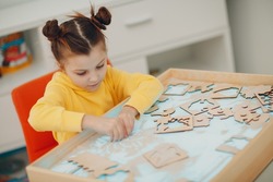 Baby girl playing with sand form toy. Early age education. Toddler cognitive psychology concept