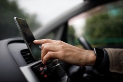 Navigator in car vehicle transportation commuter. Driver man using mobile phone navigator app while driving car vehicle