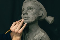 Man sculptor creates sculpt bust clay human woman sculpture. Statue craft creation workshop.