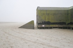 A concrete bunker from World War Two on the beach in Cape May, New Jersey, on a foggy day.