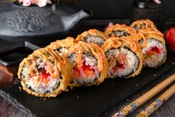 Hot fried Sushi Roll with salmon, eel, calf caviar and cheese. Sushi menu. Japanese food. Hot fried Sushi Roll