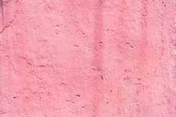 Cement texture or pink concrete wall for the background. High resolution through pink retouching process. A beautiful old pink concrete wall. The surface of the walkway surface has weathered.