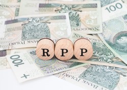Word RPP written in polish with wooden blocks standing on money, 