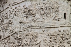 Fragments of  Roman triumphal Trajan's column, ancient monument on streets of Rome, capital of Italy, near the Colosseum and famous Forum. It commemorates Roman emperor's victory in the Dacian Wars.
