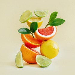 pyramid of citrus fruits grapefruit, orange, lemon, lime on yellow background
