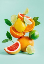 pyramid of citrus grapefruit, lemon, orange and lime decorated with leaves on a blue background