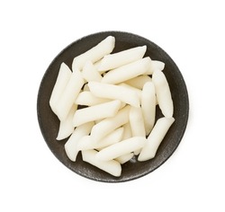 top view flat lay Tteok or Korean Rice Cakes in plate isolated on white background. pile of Tteok or Korean Rice Cakes in dish isolated on white background. Tteok Korean Rice Cakes