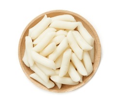 top view Tteok or Korean Rice Cakes in wood plate isolated on white background. pile of Tteok or Korean Rice Cakes in wooden dish isolated. Tteok Korean Rice Cakes flat lay                       