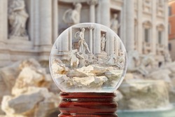 One of the most significant sights of Rome - the Trevi Fountain on a bright summer day without people through a glass transparent ball