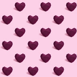 Seamless pattern with dark red or purple polygonal paper heart on pink background. Wallpaper for Valentines Day. Love concept. Bright colors. Minimal style.