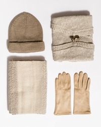 Autumn warm clothing beige colored, folded knitted wear, hat, scarf, gloves, sweater. Creative Flat lay from female fashion autumnal outerwear for cold weather in fall season.
