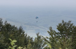 Mountains, fog, Paraglider. Parachuter. Paragliding in mountains. Paragliding sport.Parachute jumper.Parachute. Extreme sports activity