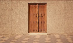 old wooden door in a stone wall, Arabic style construction                             