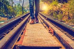 Man jeans and sneaker shoes walking on Railroad