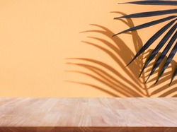 Selective focus.Nature product display with wood table counter on palm leaf in vibrant color background.For key visual layout