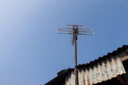 Photo of an old-fashioned antenna against a blue sky in the background