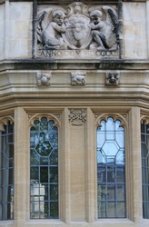 statue and stonework outside St John's college Oxford part of the university with the college coat of arms held by two angels or cherubs and Sir Thomas White's crest made in 1900