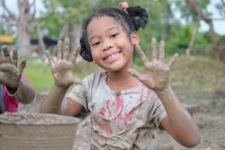 Kids enjoying with muddy puddle ground, Children in the poor country playing together in the nature happily