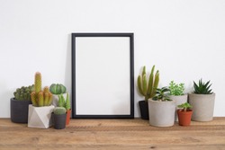 Cactus with black frame poster on table in room.trendy home decoration