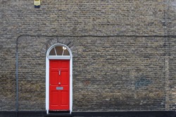 single red door on brick wall