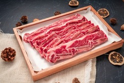 Cross Cut Short Ribs beef on wooden plate, Beef Short Ribs (Sliced) on wooden background.