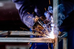 welder and welding sparks, construction and metal work industrial concept, metal welding with sparks, laborer or labor day concept