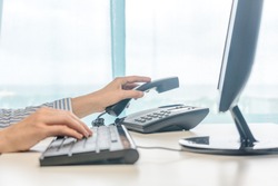 Female working, hands using computer telephone, closeup