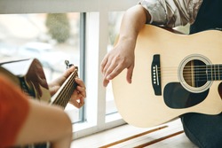 Learning to play the guitar. The teacher explains to the student the basics of playing the guitar. Individual home schooling or extracurricular lessons.