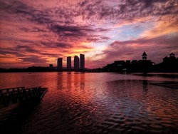 Jetty at lakeside with colourful Sunrise, Pullman, Putrajaya, Malaysia. Image has grain or blurry or noise and soft focus when view at full resolution (Shallow DOF, slightly motion blur).