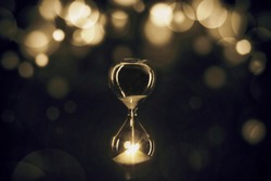 Golden Hourglass with bokeh light, abstract meaning of best time of business, celebration time
