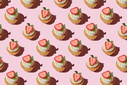 Pattern made of home cookies with strawberries and cream on a pink background. cupcake with big strawberry on top. Repeating  homemade cookies with strawberries and cream pattern. Flat lay style.