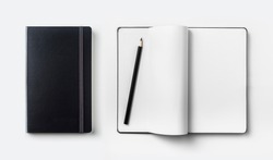 Business concept - Top view collection of black hardcover notebook, white open & flip curl rolled page and black pencil isolated on background for mockup