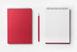 Design concept - Top view of red spiral notebook and color pencil collection isolated on white background for mockup