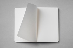 Design concept - top view of white notebook with blank open, turn and flipped page on grey background for mockup. real photo, not 3D render