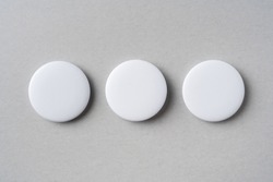 Design concept - top view of 3 white badge on grey background for mockup, it's real photo, not 3D render