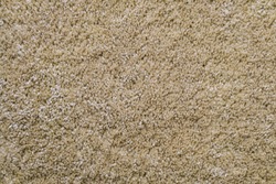 Texture of beige frieze carpet. Artificial wool material carpeting.