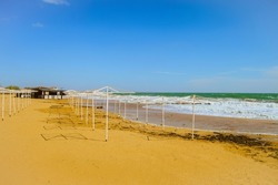Sunny sandy beach in Feodosia Bay in Black sea. Empty beach in autumn season.