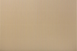 Texture of corrugated light beige paper, macro. Striped pattern of brown cardboard background, closeup.