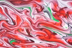 Abstract fluid art background red and white colors. Liquid marble. Acrylic painting on canvas with green lines and gradient. Alcohol ink backdrop with pink wavy pattern.