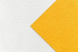 Texture of white and bright yellow paper background, half two colors with arrow, macro. Structure of dense craft orange cardboard. Felt abstract backdrop closeup.
