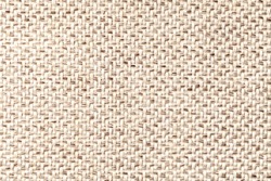 Beige vintage fabric with woven texture closeup. Textile background macro.