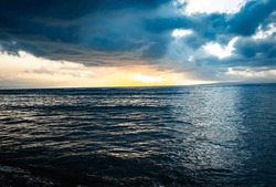 Dark clouds gather over the sear on a Sindhu Beach sunrise at Sanur, Bali, Indonesia