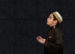 Muslim kid in white traditional clothes, praying at Kaaba in Makkah. High quality photo